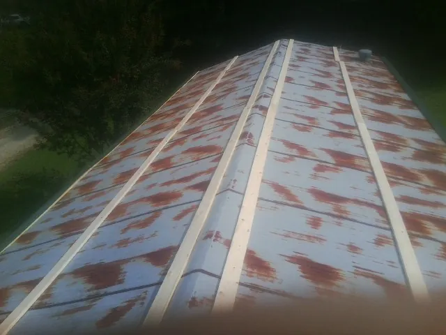 Rusted metal roof panels with new wood purlins before replacement — Storm Damage Roof Repair in Lutz by Roofing Brothers